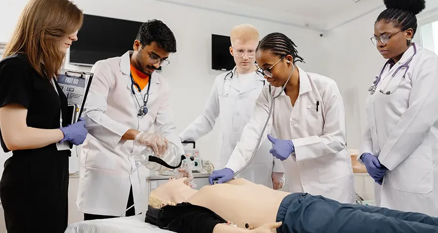 Medical students practicing CPR on a training dummy during a class session.