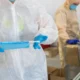 Workers handling the industrial production of protective medical masks in a factory.