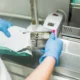 Nurse hand packing sterilized dental instruments into plastic bags in a healthcare facility.