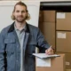 Smiling man working in a medical supply warehouse, surrounded by inventory boxes.