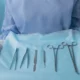 Medical professional holding a tray filled with surgical instruments, ready for use in an operation.