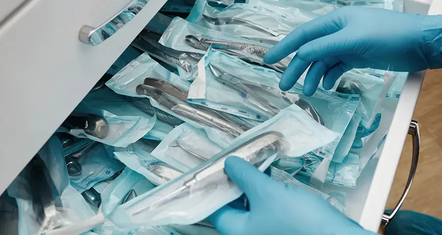 Lab technician holding a sterile set of disposable dental instruments.