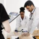 Group of students learning cardiopulmonary resuscitation (CPR) using training dummies in an educational setting.