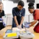 Students practicing CPR in a classroom as part of hands-on medical training.