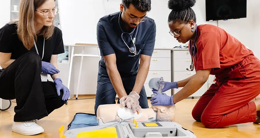 Students practicing CPR in a classroom as part of hands-on medical training.
