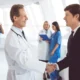 Doctor and business professional shaking hands, symbolizing a reliable medical supply partnership.