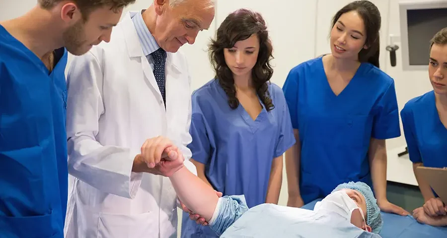 Medical students and instructor performing a hands-on training session by checking a pulse.