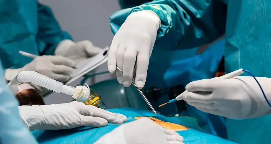 Surgeons in full scrubs performing a medical procedure in an operating room, demonstrating clinical training.