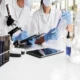 Two female scientists conducting a chemical experiment in a lab, representing collaborative medical research.