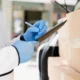 Close-up of a person verifying a delivery list for wholesale medical supplies.