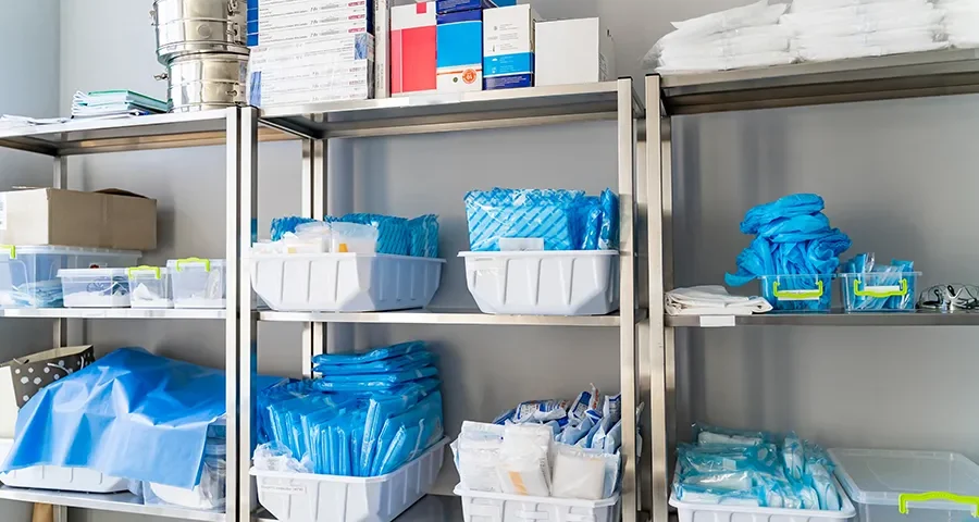 Organized storage room in a clinic with surplus medical equipment and supplies for institutional use.