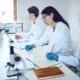 Medical students collaborating with a professor in a laboratory setting for research and training.