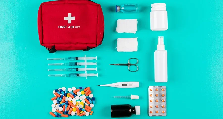 Flat lay of a medical emergency kit with expired or soon-to-expire medical supplies