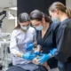 Dental students performing practical treatment with real patients in a training classroom