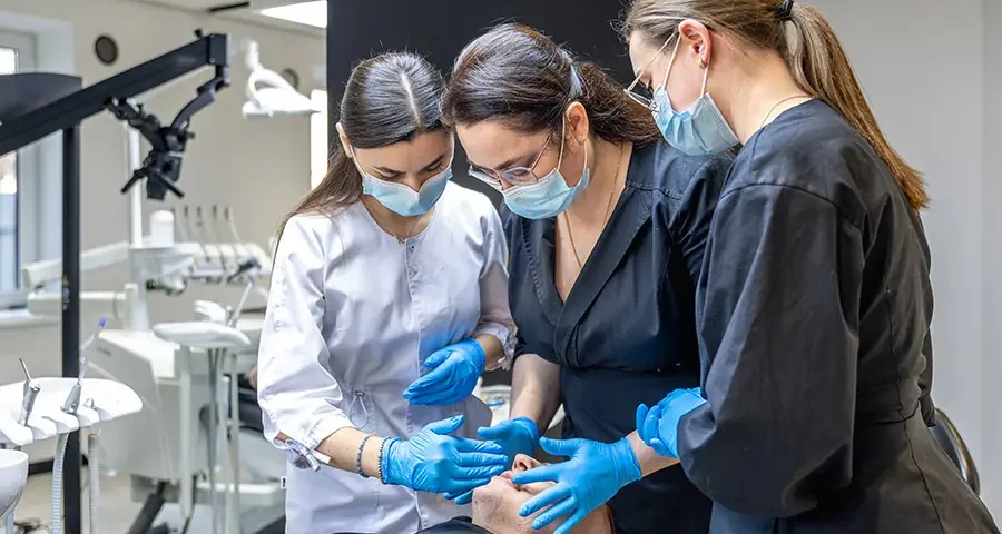 Dental students performing practical treatment with real patients in a training classroom