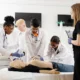 Medical students practicing CPR techniques on a mannequin during hands-on classroom training