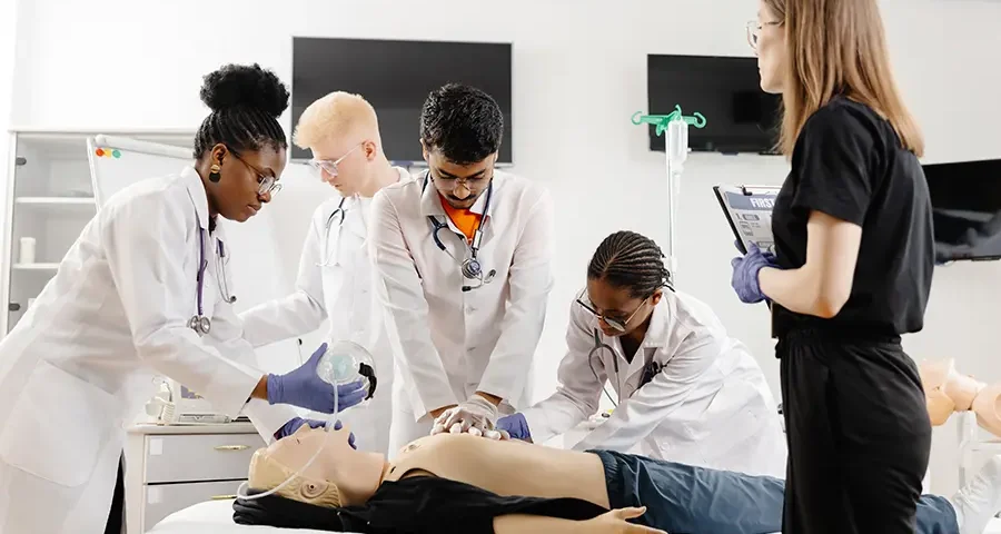 Medical students practicing CPR techniques on a mannequin during hands-on classroom training