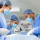 Team of professional surgeons performing an urgent surgical operation in a sterile hospital operating room