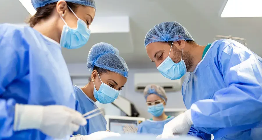 Team of professional surgeons performing an urgent surgical operation in a sterile hospital operating room